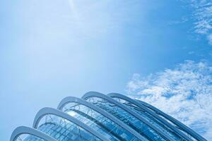 Kurve geometrisch Stahl metallisch Verkleidung auf ein generisch modern Gebäude mit Blau Himmel foto