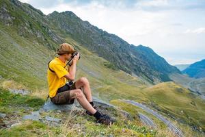 junger männlicher Fotograf in den Bergen foto