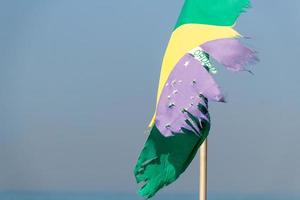 verblasste und zerrissene brasilianische Flagge im Freien am Strand der Copacabana foto