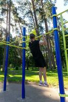 Porträt von schön Teen Alter sportlich Mädchen Ausbildung draußen beim öffnen Luft Fitnessstudio beim Sommer- sonnig Tag foto