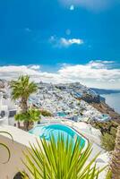 schön Aussicht von berühmt romantisch Weiß Stadt, Dorf im Santorini Insel, Griechenland . Luxus Hotel Schwimmen Schwimmbad mit Palme Bäume und Weiß die Architektur, Sommer- Ferien oder Urlaub Konzept. Fantastisch Reise Szene foto