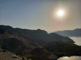 ein schön tagsüber Aussicht von Wadi qanuna Damm im al Bahah, Saudi Arabien. das Wasser von das Damm und das Umgebung Hügel sind präsentieren ein schön Szene im das Sonnenlicht. foto