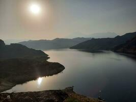 ein schön tagsüber Aussicht von Wadi qanuna Damm im al Bahah, Saudi Arabien. das Wasser von das Damm und das Umgebung Hügel sind präsentieren ein schön Szene im das Sonnenlicht. foto