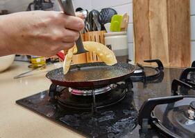 Kochen Krepp suzette Pfannkuchen im braten schwenken auf Gas Herd foto