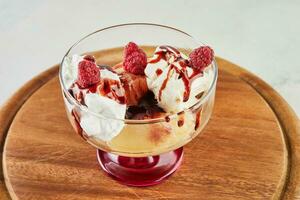 Dessert mit Himbeeren, cremig Eis Sahne und ausgepeitscht Sahne im Besondere Glas foto