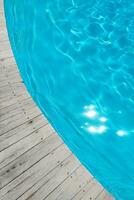 azurblau transparent Textur von Wasser im ein Blau Schwimmbad mit spritzt von das Sonne foto