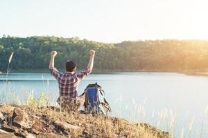 glückliche Zeitwanderer-Mann-Touristen mit dem Genießen auf einem Berg. foto