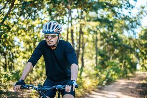 der Mann, der auf einem Bergpfad Fahrrad fährt a foto