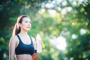 Fitness-Frau Trinkwasser aus der Flasche. foto