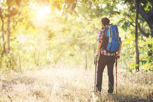 junger Hipster-Mann zu Fuß auf der Landstraße bei Wanderungen im Urlaub. foto