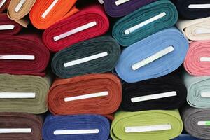 Detaillierte Nahaufnahme von Mustern von Stoffen und Stoffen in verschiedenen Farben, die auf einem Stoffmarkt gefunden wurden foto