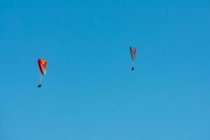 Gleitschirm Paar fliegend mit ein Blau Himmel foto