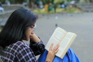 glücklich achtsam jung asiatisch Frau Hochschule Schüler lesen ein Buch im das Park, Bildung Konzept foto