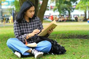 jung Frau asiatisch Schüler lesen ein Hinweis Buch Ernsthaft zu bereiten Untersuchung foto