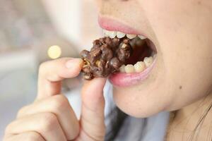 Nahansicht von ein Frau Mund Essen Essen foto