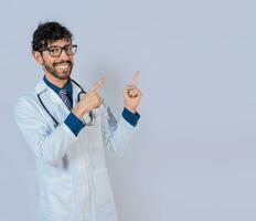 bärtig Arzt zeigen ein Beförderung mit Finger isoliert. glücklich bärtig Arzt zeigen beim Werbung Raum isoliert foto