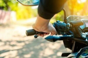 Hände von ein Motorradfahrer auf das Lenker, schließen oben von das Hände auf das Lenker von ein Motorrad. Hände von ein Person auf das Motorrad Lenker. Motorrad Beschleunigen Konzept foto