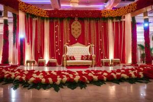 ein indisch Hochzeit Bühne dekoriert mit rot und Gold Blumen. KI-generiert foto