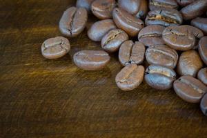 extreme Nahaufnahme Kaffeebohnen auf Holzuntergrund, dunkler Ton foto