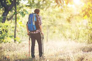 junger Hipster-Mann zu Fuß auf der Landstraße bei Wanderungen im Urlaub. foto