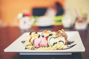 Eisbecher Vanille-Erdbeer-Schoko-Zitronen-Kugeln mit Banane foto