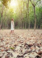 schöne junge frau, die traurig auf dem grünen waldweg steht foto