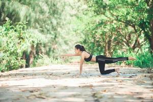 junge asiatische frau, die morgens yoga im park macht. gesund foto