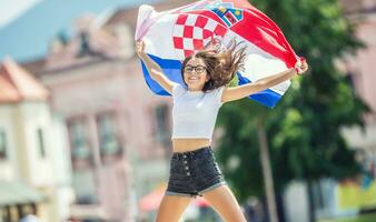 glücklich Mädchen Tourist Gehen im das Straße mit kroatisch Flagge foto