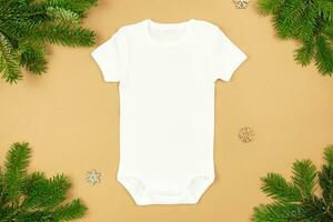 Weihnachten Weiß Baby Mädchen oder Junge Bodysuit Attrappe, Lehrmodell, Simulation eben legen mit Weihnachten Baum Geäst und Schneeflocken Dekoration auf Papier Hintergrund. Design Strampler Vorlage, drucken Präsentation spotten hoch. oben Sicht. foto