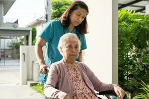Pflegekraft Hilfe und Pflege asiatisch Senior Frau geduldig Sitzung auf Rollstuhl zu Rampe im Krankenhaus, gesund stark medizinisch Konzept. foto