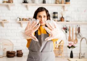 lächelnde Frau, die sich darauf vorbereitet, Ostereier in der Küche zu färben foto