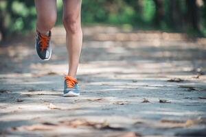 Beine einer gesunden Frau beim Joggen am Morgen im Park. foto