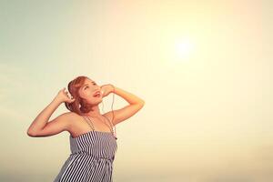 schöne sexy Frau, die Musik vom Smartphone in der Blume hört. foto