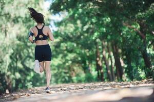 junge Fitnessfrau, die im Park joggt. foto