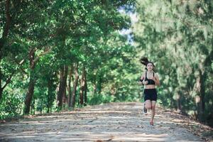 junge Fitnessfrau, die im Park joggt. foto