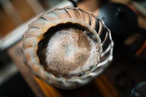 Tropfkaffee im Haus, heißes Wasser über einen Tropfkaffee gießen foto