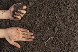 Hand hält schwarzen Boden für den Anbau von Pflanzen Weltbodentag Konzept