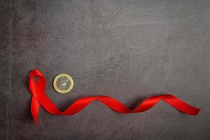 Rote Bänder und Kondome werden auf einem Tafelhintergrund platziert