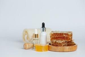 natürliche Hautpflegeseife und -serum mit Honig und Waben gelegt foto