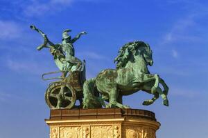 Statue Darstellen Krieg, ein Mann halten ein Schlange auf ein Streitwagen, auf ein Kolonnade im Helden Platz oder hosok tere, Budapest, Ungarn. foto