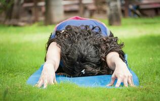 schließen oben von Mädchen tun Dehnen Yoga, Mädchen tun bharata Yoga, jung Frau tun Dehnen Yoga draußen foto