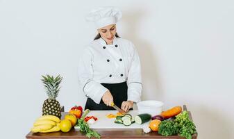 ein Frau Koch Schneiden frisch Gemüse, Konzept von ein weiblich Koch vorbereiten frisch Gemüse. Porträt von weiblich Koch Schneiden Gemüse, weiblich Koch vorbereiten Salat foto