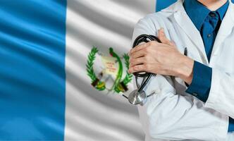 Arzt mit Stethoskop auf Guatemala Flagge. Gesundheit und Pflege mit das Flagge von Guatemala. Guatemala National Gesundheit Konzept, Arzt Arm mit Stethoskop auf Guatemala Flagge foto