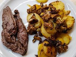 Flankensteak mit Waldpilzen und Bratkartoffeln foto