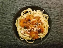 weiße Tigergarnelen in Erdnusssauce auf Spaghetti