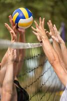 gruppe junger freunde, die beachvolleyball spielen foto