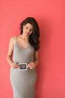 glückliche schwangere frau, die ultraschallbild zeigt foto