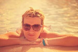 Frau genießen Ferien im das Schwimmen Schwimmbad foto