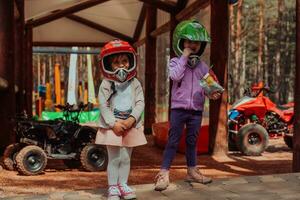 zwei wenig Mädchen haben Spaß im das Park während tragen ein Motorrad Helm auf ihr Köpfe foto