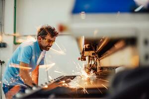 innerhalb der Schwerindustrie. Ein Mann arbeitet in einer modernen Fabrik an einer CNC-Maschine. selektiver Fokus foto